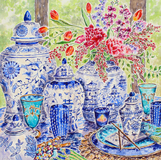 a large square watercolor painting of chinoiserie blue and white china with a bouquet of flowers.  The china is surrounded by beautiful teal glassware, plates, a woven placemat and chopsticks.  The background shows soft green trees