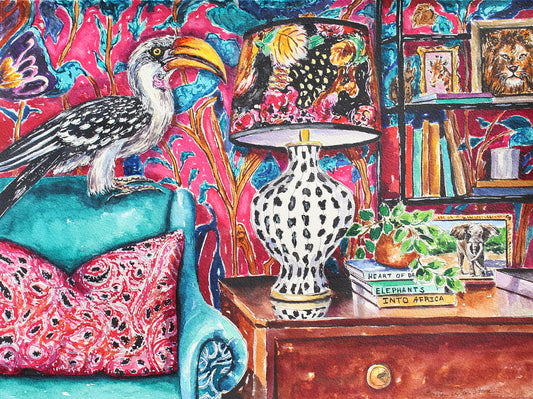 A Giclee print of an African Yellow Billed Hornbill sitting on the back of a chair in a room with bookshelves, a lamp, and decorative items.  Wall decor for art collectors.