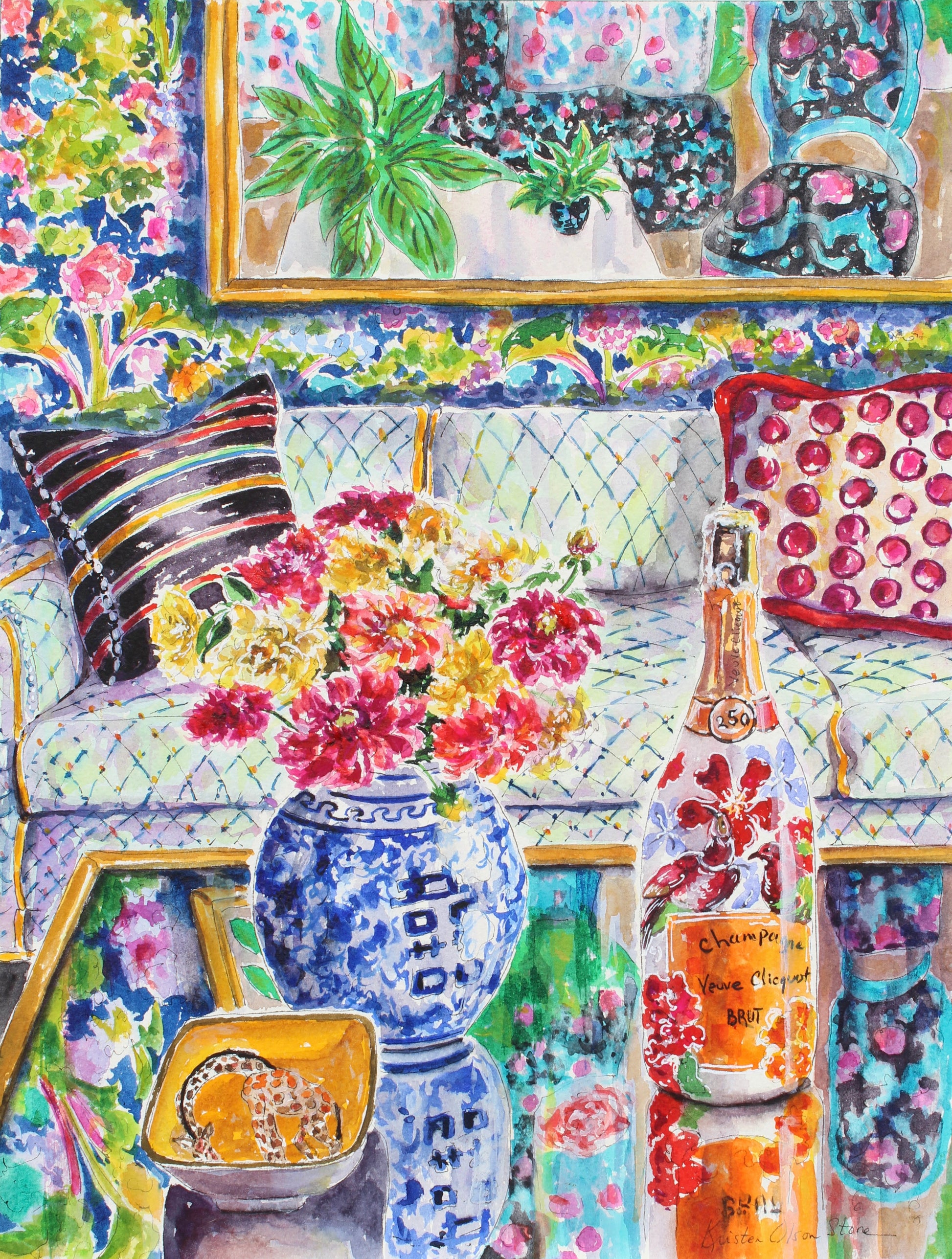 Colorful interior scene with a sofa, Chinoiserie blue vase of flowers, and a limited edition Champagne bottle of Veuve Clicquot on a coffee table. A small yellow bowl with a giraffe sits on the table as well and reflections of interesting patterns are on the table surrounding the bottle and vase.  Floral wallpaper and decorative pillows complete the scene.  Wall decor for art lovers.