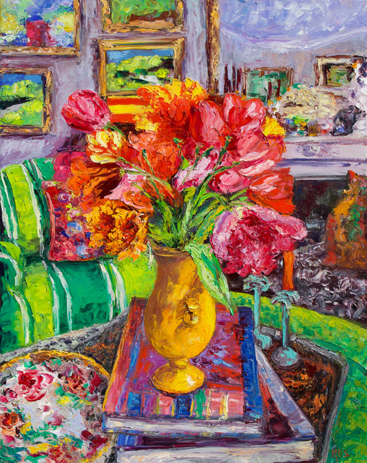 A colorful oil painting depicting a vibrant bouquet of red, pink, and orange tulips in a yellow vase, set on a table in a cozy living room with a green striped sofa and framed art in the background.