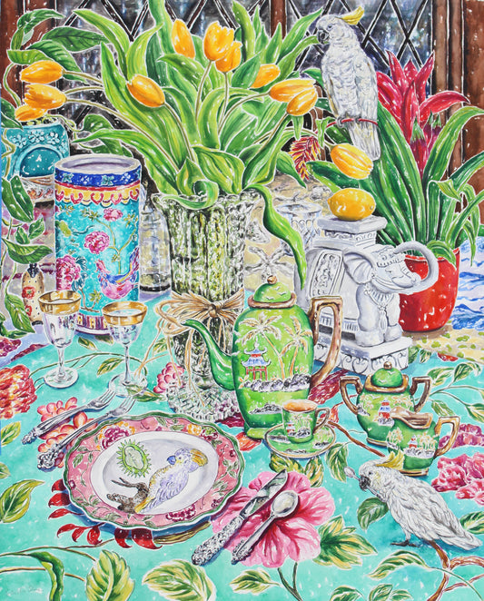 A colorful watercolor painting of an eclectic table setting  with chinoiserie vases featuring two yellow crested white cockatoos, a crystal vase of yellow tulips, a lemon on an elephant sculpture, and various other decorative items on a table including a teal blue hibiscus tablecloth.  Wall decor for art lovers.